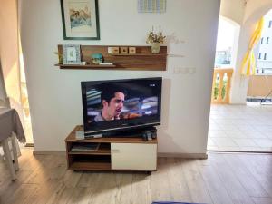 a flat screen tv sitting on a stand in a living room at Apartments Mare Family only in Mandre