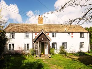 a white house with a chimney on top at Prospect Place by The Suffolk Cottage Collection in Westleton