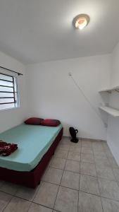 a bedroom with a bed in a white room at Casa até 4 pessoas Rua Corrupiao Bombas in Bombinhas