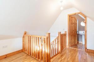 a room with a wooden staircase with a door at Cute cottage for short getaway in Cross Mahon