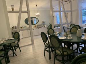 a dining room with black tables and chairs at Pension Gerber in Erfurt