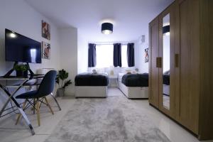 a room with two beds and a table and a desk at listing SALE - Entire Town Centre Apartment Free Parking WiFi in Colchester