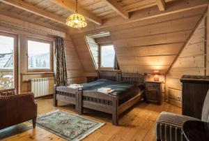 1 dormitorio con 1 cama en una habitación con paredes de madera en Góralski Spa - Luksusowa willa z sauną i wanną z hydromasażem, en Kościelisko