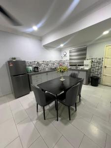 a kitchen with a table and chairs in a room at Mus Lim Homestay Bandar Tasik Puteri in Rawang
