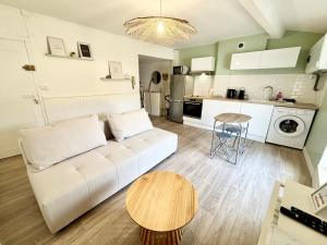 een woonkamer met een witte bank en een tafel bij Confort & Cosy Proche centre ville in Valence