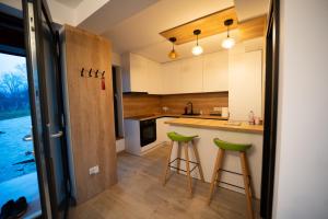 a kitchen with two green stools in front of a counter at EcoTravel New in Suceava