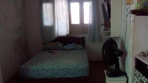 a small bedroom with a bed and a window at Aconchegante e familiar in Marituba