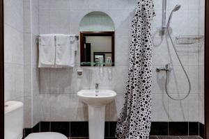 La salle de bains est pourvue d'un lavabo et d'une douche. dans l'établissement Peterville, à Saint-Pétersbourg