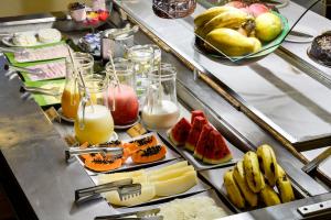 a buffet line with fruits and juice and fruit at Pousada Estalagem Casa Grande in Ubatuba