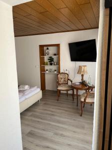 a room with a bed and a table and a television at Schreiber-FeWo 02 in Bad Bocklet +7 photos