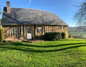 a wooden house with a large grassy yard at Gîte " Le Normand " Sa Vue Splendide in Vimoutiers