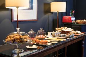 a buffet with bread and pastries on a table at Hotel Ismael - Lastarria in Santiago