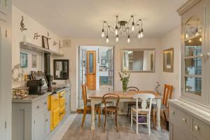 eine Küche mit Esstisch und Stühlen in der Unterkunft 17th Century Cottage in Bideford Private Parking in Bideford