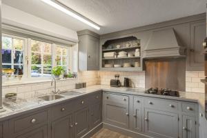 eine Küche mit grauen Schränken und einer Spüle in der Unterkunft 17th Century Cottage in Bideford Private Parking in Bideford