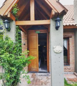 - une entrée pour une maison avec une porte en bois dans l'établissement Shamrock House - Casa de Vacaciones en Merlo, San Luis, à Merlo