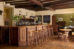 a bar in a restaurant with stools at a counter at The Merry Harriers Pub in Hambledon