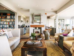 Una sala de estar con un sofá y una chimenea. en Spinneys Beachfront by The Suffolk Cottage Collection, en Thorpeness