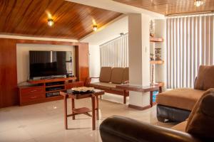 ein Wohnzimmer mit Sofa, Fernseher und Tisch in der Unterkunft Antares Arequipa in Arequipa