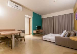 a room with a bed and a table and a couch at Apartamento Enjoy Solar das Águas Park Resort in Olímpia