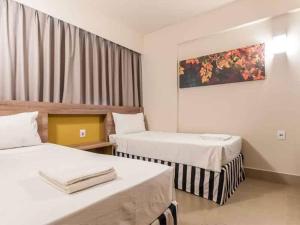 a hotel room with two beds and a window at Apartamento Enjoy Solar das Águas Park Resort in Olímpia