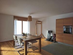 a dining room with a wooden table and chairs at Modern Apartment Davos WEF in Glaris