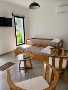 a room with two beds and a table and chairs at La Elenita Tandil in Tandil