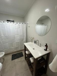 a white bathroom with a sink and a mirror at La Elenita Tandil in Tandil +22 photos