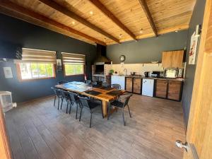 a kitchen and dining room with a wooden table and chairs at Cabañas Montenegro in Los Ángeles