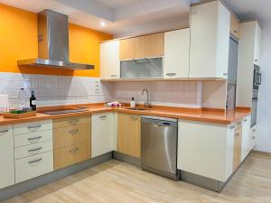 a kitchen with white cabinets and stainless steel appliances at Suites Esencia Atlántica Confort cerca del mar in Telde +19 photos