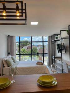 a bedroom with a bed and a large window at Flat 202 Home Business Centro Pomerode in Pomerode