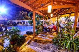 a patio with a table and chairs next to a pool at Pousada Estalagem Casa Grande in Ubatuba +65 photos