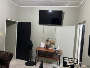 a living room with a tv on the wall at Netfa's Hidden Gem in Kingston
