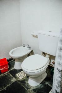 a bathroom with a white toilet and a sink at La Curva in El Bolsón +17 photos