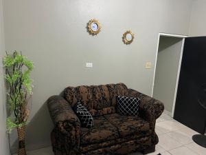 a couch in a living room with two mirrors on the wall at Netfa's Hidden Gem in Kingston