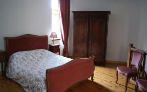 a bedroom with a bed and two chairs at Le Pentagone in Bruniquel