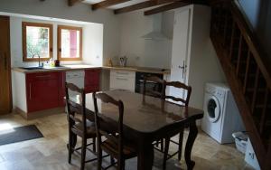 a kitchen with a table and chairs and a washing machine at Le Pentagone in Bruniquel +7 photos