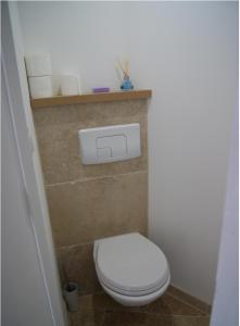 a bathroom with a white toilet in a room at Le Pentagone in Bruniquel