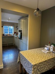 a kitchen with a table with a polka dot table cloth at Cosy 2 bed cottage in beautiful Orford in Orford +3 photos