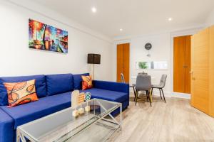 a living room with a blue couch and a table at Central Apartments near Marble Arch in London