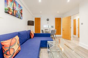 a living room with a blue couch and a table at Central Apartments near Marble Arch in London +17 photos