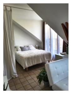 a bedroom with a white bed and a white couch at idéal studio in Gap
