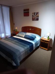 Un dormitorio con una cama con un edredón azul. en Apart Hotel Agustinas Plaza, en Santiago 40 fotos más