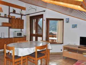 kuchnia ze stołem, krzesłami i kuchenką mikrofalową w obiekcie Appartement cosy au cœur du village, avec balcon, acceptant animaux - Idéal familles! - FR-1-692-7 w mieście La Chapelle-dʼAbondance