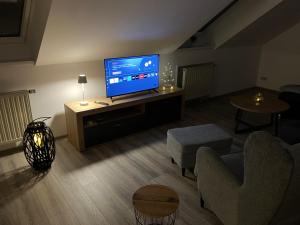 a living room with a flat screen tv on a table at FEWO-Wölkchen mit Ausblick & Komfort über den Dächern von Weißenfels in Weißenfels
