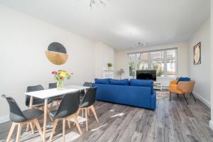 a living room with a blue couch and a table at Spacious Boutique 2 Bed Apartment Retreat Flexi BM in Finchley