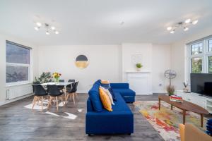 a living room with a blue couch and a table at Spacious Boutique 2 Bed Apartment Retreat Flexi BM in Finchley