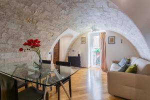 a living room with a glass table and a stone wall at Palazzo di città Bari in Bari