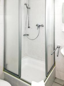 エアフルトにあるCozy apartment in the heart of Erfurt 30 m² city viewの浴室のガラス扉付きシャワー