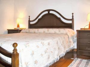 ein Schlafzimmer mit einem großen Bett mit einem hölzernen Kopfteil in der Unterkunft Charming house in Ourol with mountain view, large garden. in Merille