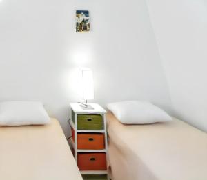 1 dormitorio con 2 camas y mesita de noche con lámpara en Charming House in Paros, 90 m² with Shared Pool, en Parikia
